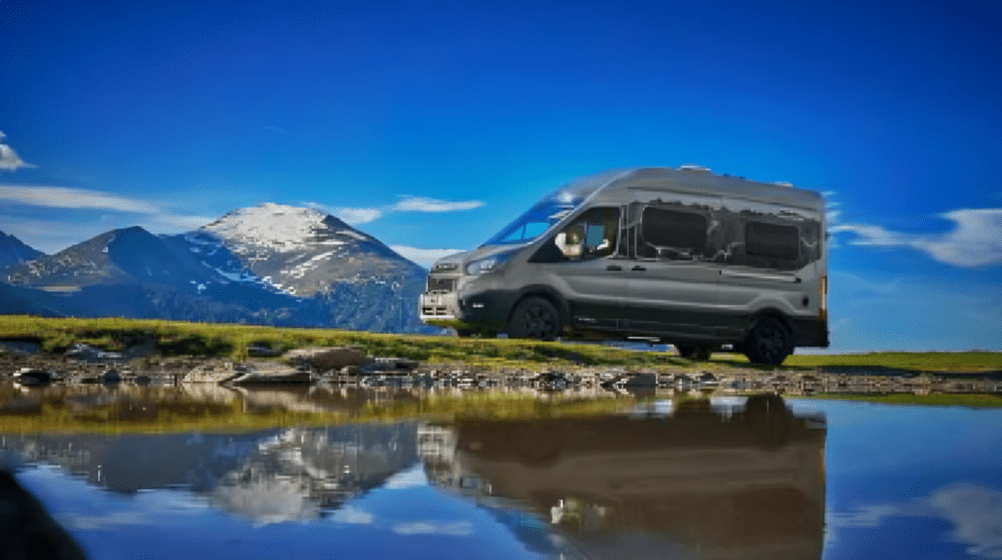 Camper van by mountain lake with reflection