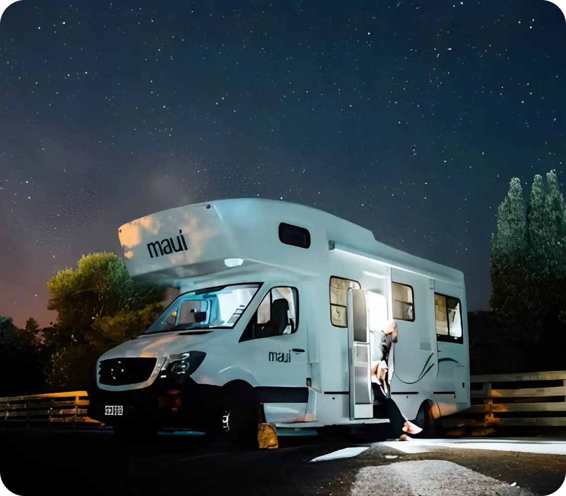 White motorhome parked under starry night sky