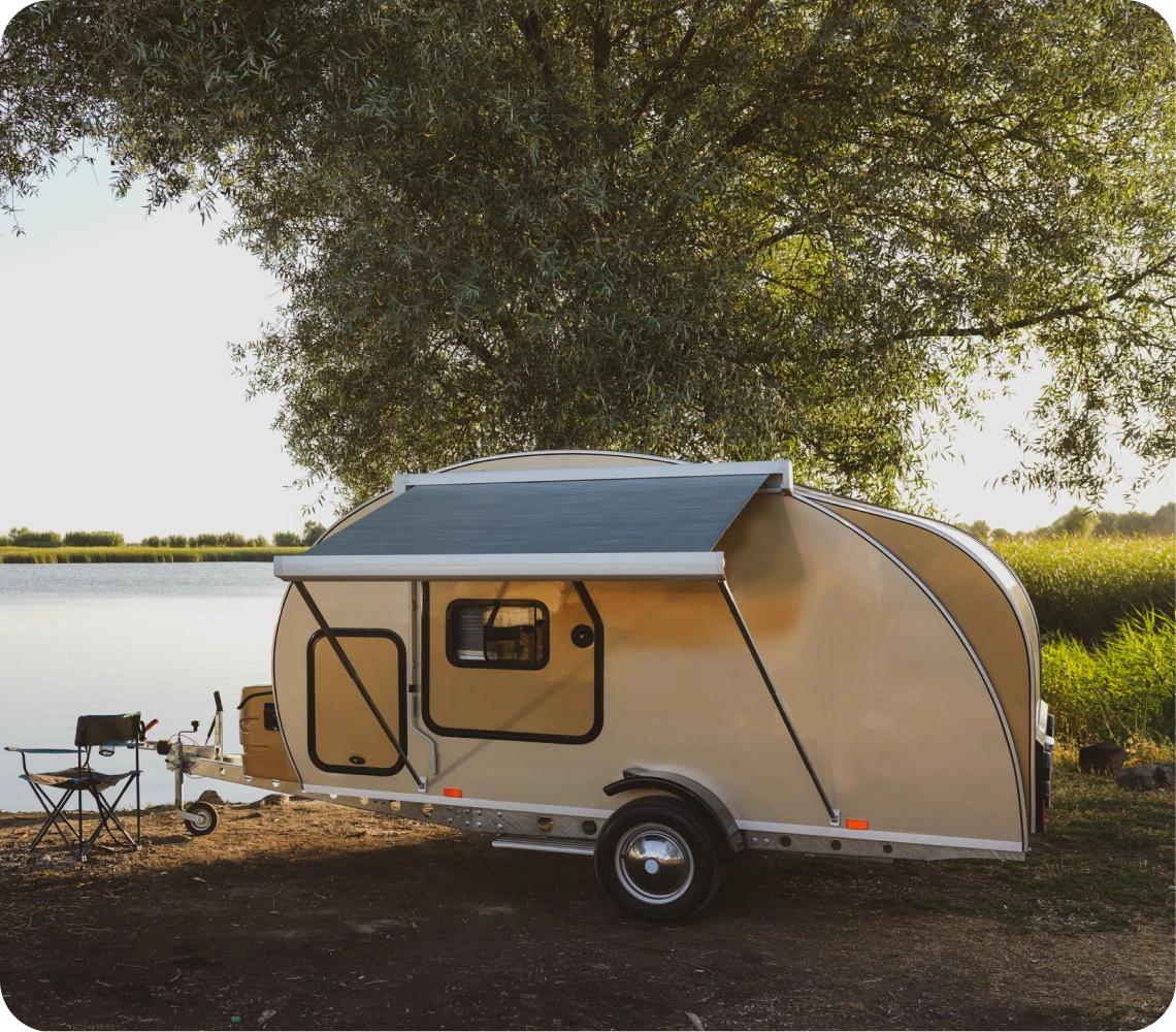 Small caravan under a large tree