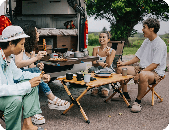 Friends enjoying roadside picnic by campervan